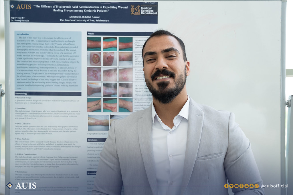 An MLS student poses next to his capstone project poster.